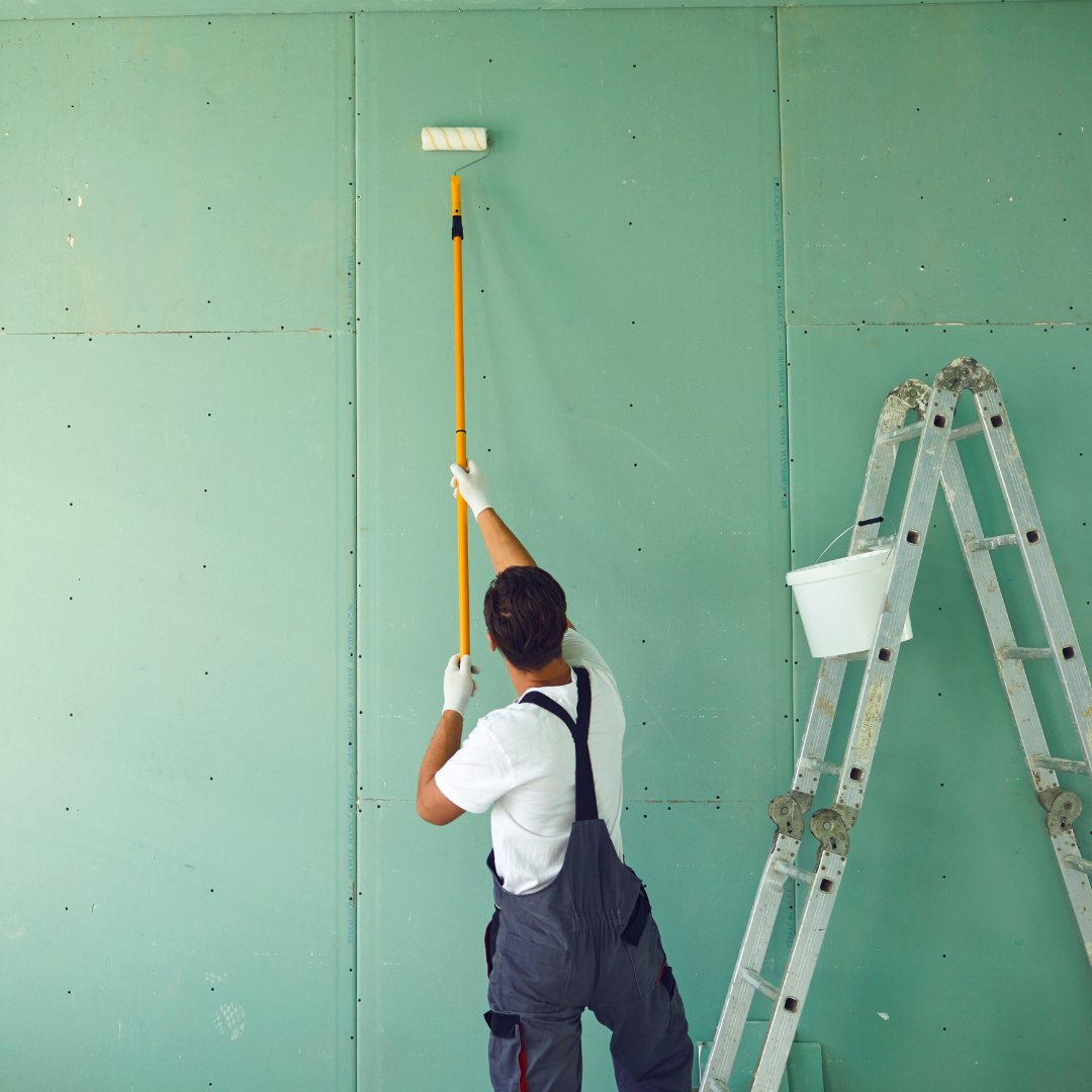 man painting green wall