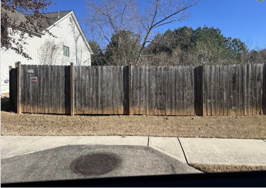 wooden fence of hoa community before being repainted
