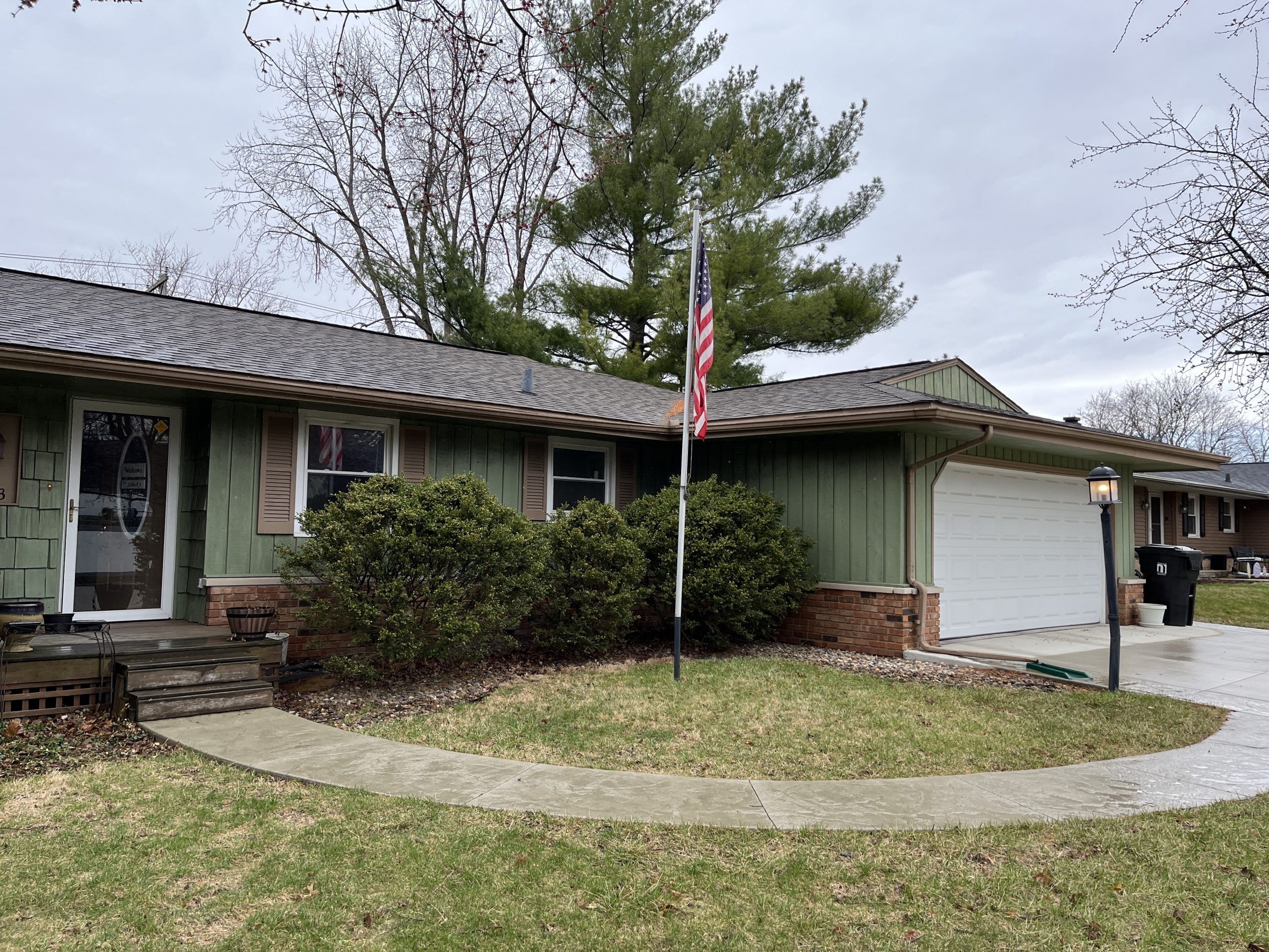 front of house with green siding and path through lawn