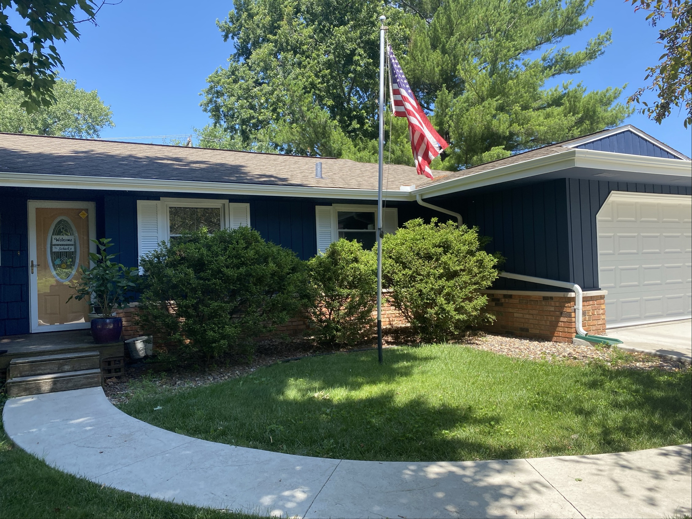 front of house with painted blue siding and path through lawn