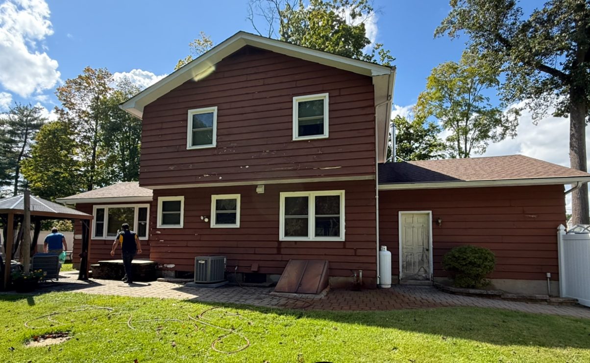 damaged red and brown siding on back of home