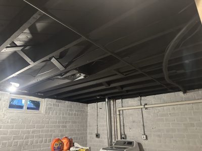 washer & dryer in room with whitewashed brick walls and black painted ceiling beams