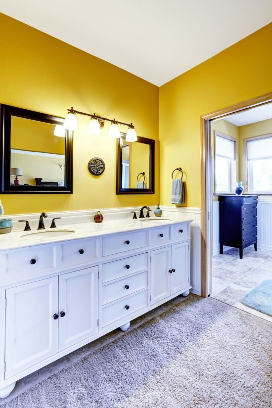 yellow bathroom owith white cabinets