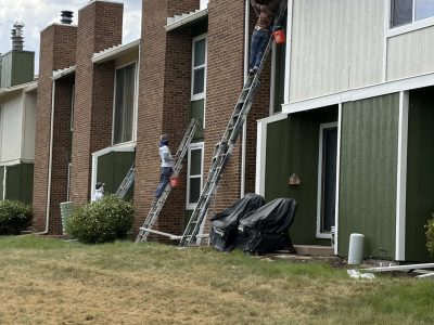 painters on ladders against townhouses during repaint