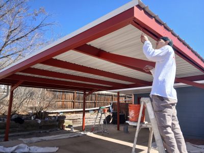 man on ladder under carport