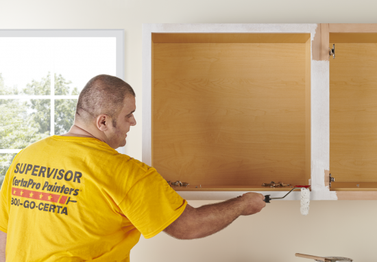 CertaPro Team Member painting kitchen cabinets