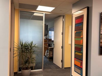 painted office hallway with framed artwork on walls