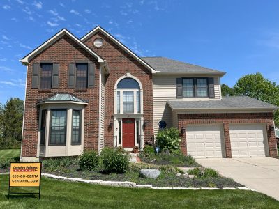 brick home with painted door, trim and siding