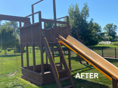 stained wooden playset in grass