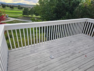 grey stained wooden deck with white railing