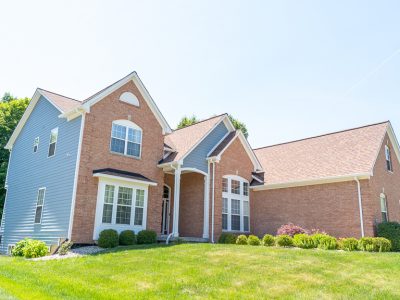 brick home with siding and trim painted
