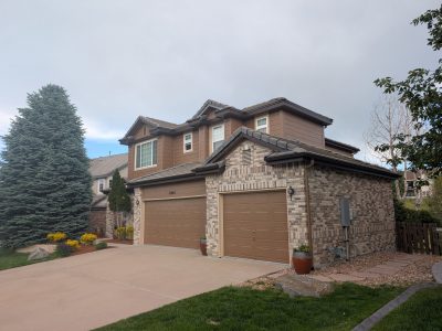house exterior with brick and brown painted siding and garage doors