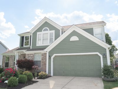 painted home with green siding and white trim