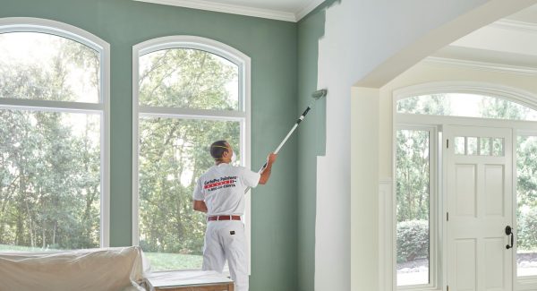 certapro painter wearing face mask while painting living room