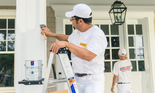 man painting exterior of house